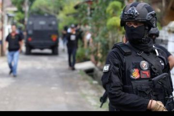 Petugas Densus 88 tengah berjaga di sekitar rumah terduga teroris di Kawasan Perumahan Kunciran Indah, Pinang, Tangerang, Banten, Rabu (16/05/2018). Sejumlah barang bukti dan tiga orang terduga teroris telah diamankan tim Densus 88 Antiteror Polri. (Sumber: KOMPAS.com / ANDREAS LUKAS ALTOBELI)