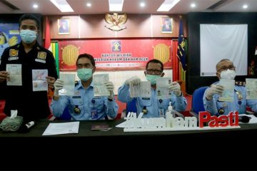 epala Kantor Imigrasi Kelas I TPI Banda Aceh Telmaizul Syatri (kanan), Kakanwil Kemenkumham Aceh Heni Yuwono, (tengah) Kepala Divisi Imigrasi Kanwil Kemenkumham Aceh Sjachril (Kiri) memperlihatkan paspor 18 warga asing dari berbagai negara yang diamankan dari kapal yacht asing, Senin (08/02/2021).