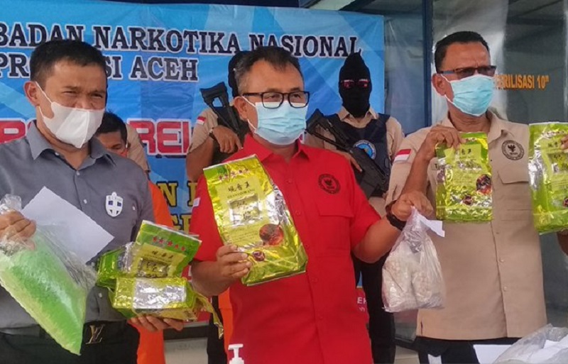 Kepala BNN Provinsi Aceh Heru Pranoto (tengah) memperlihatkan barang bukti sabu-sabu dan pil ekstasi yang hendak diselundupkan ke Sumatera Utara di Kantor BNN Provinsi Aceh di Banda Aceh, Selasa (13/10/2020). Antara Aceh/M Haris SA
