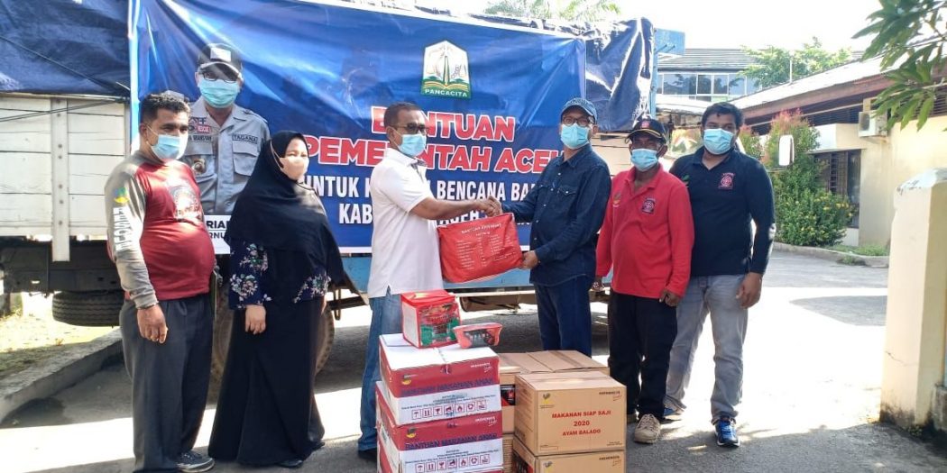 Kepala Bidang Linjamsos, Syukri M.Pd saat menyerahkan bantuan Pemerintah Aceh secara simbolis untuk korban banjir di Aceh Utara yang diterima Kepala Dinas Sosial Aceh Utara, Fuad Mukhtar, S.Sos., M.S.M, di Kantor Dinas Sosial Aceh Utara, Sabtu (2/10/2021).