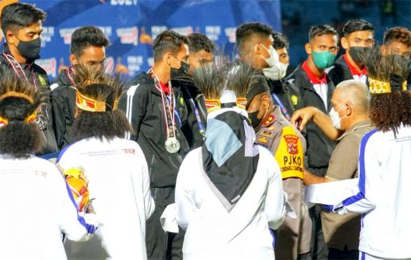 Sekda Aceh, dr.Taqwallah, M.Kes mengalungkan mendali perak kepada tim sepakbola Aceh di Stadion Mandala, Jayapura. [Foto: Humas BPPA]