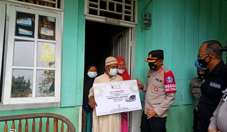 Kapolres Aceh Tamiang, AKBP Imam Asfali saat menyerahkan hadiah umroh gratis ke rumah Sudarman di Dusun Sedar, Kampung Sriwijaya, kecamatan Kuala Simpang, Aceh Tamiang, Jum'at (12/11/2021). Foto: Nukilan/Poris
