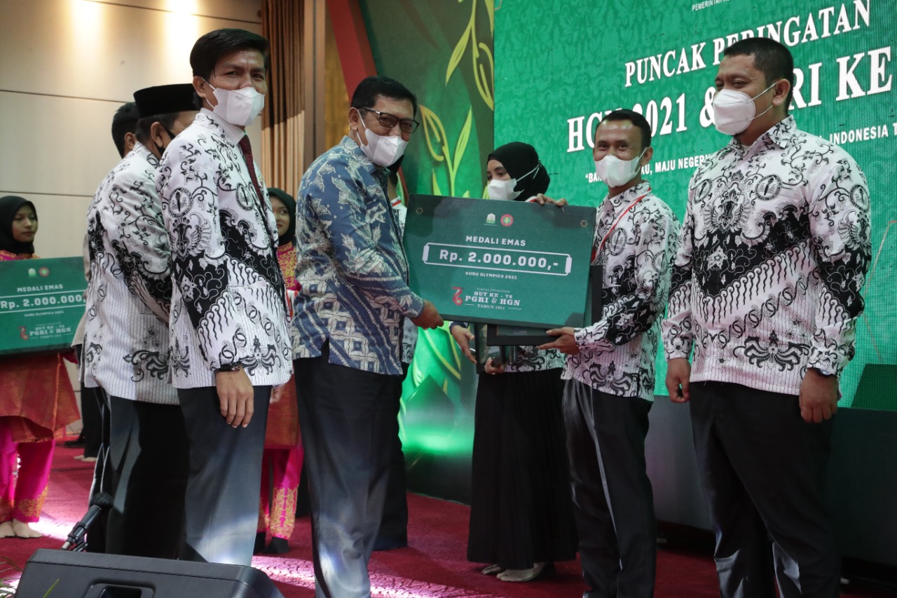 Kepala Dinas Pendidikan Aceh, Alhudri saat menyerahkan penghargaan kepada Guru pada malam puncak HGN 2021. (Foto: Dok. Ist)