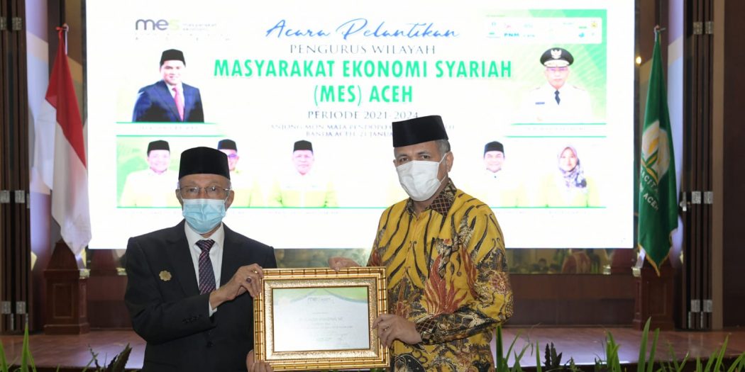 Gubernur Aceh, Ir. H. Nova Iriansyah, MT, saat menerima piagam penghargaan dari Masyarakat Ekonomi Syariah (MES) Aceh, sebagai Tokoh Motivator Konversi Qanun Lembaga Keuangan Syariah di Aceh, yang diserahkan oleh Paduka Yang Mulia (PYM) Wali Nanggroe Aceh, Malik Mahmud Al-Haytar, di Anjong Mon Mata, Banda Aceh, Jumat (21/1/2022) malam. Foto: Humpro