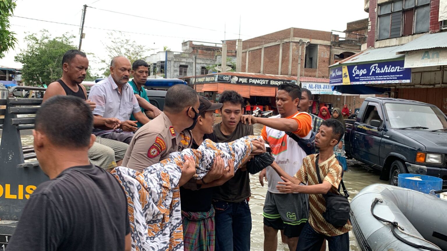 Warga dibantu TNI dan polisi mengevakuasi seorang bocah yang meninggal setelah tenggelam saat banjir di Matangkuli Aceh Utara. (Foto: bisaapa.id)