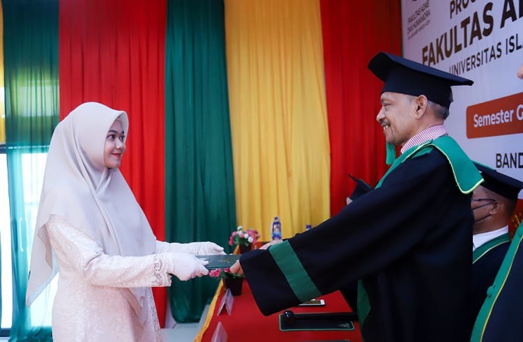 Dekan FAH UIN Ar-Raniry, Dr Fauzi Ismail MSi menyerahkan surat keterangan lulus dan transkrip nilai sementara bagi lulusan semester ganjil tahun akademik 2021/2022 pada Prosesi Yudisium, (Foto: Dok.Ist)