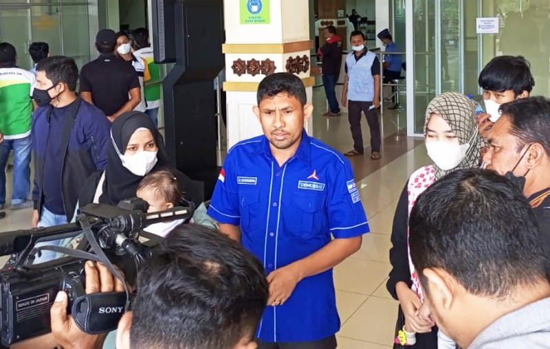 Tenaga Ahli Teuku Riefky Harsya, Aidil Mashendra bersama dua orang tua bayi bocor jantung saat tiba di Bandara Sultan Iskandar Muda (SIM), Aceh Besar. Kamis (27/1/2022), Foto: Nukilan/MIR.