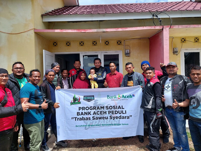 Direktur Dana dan Jasa Bank Aceh, Amal Hasan (tengah), didampingi orang tua Mauza Dilara, dan komunitas Trabas dan Baskom melakukan sesi foto bersama saat melakukan kunjungan sosial ke Desa Lhok Buya, Kecamatan Setia Bakti, Aceh Jaya