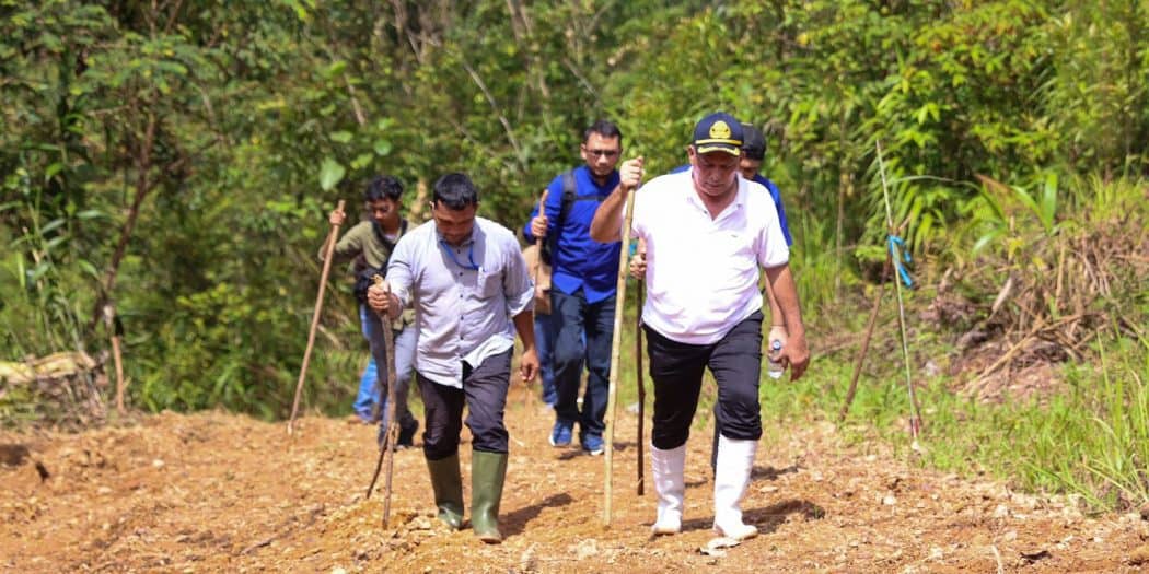 Sekretaris Daerah Aceh, dr. Taqwallah, M.Kes, didampingi Asisten II Sekda Aceh, Junaidi, ST, MT, Kadis PUPR Aceh Mawardi, ST, Kalak BPBA, Dr. Ir. Ilyas, MP, dan Karo Adpemb Setda Aceh, T. Robby Irza, S.iT, MT, berjalan kaki saat meninjau pembangunan jalan batas Aceh Besar-Lamno, Jumat, (18/3/2022). Foto: Humpro