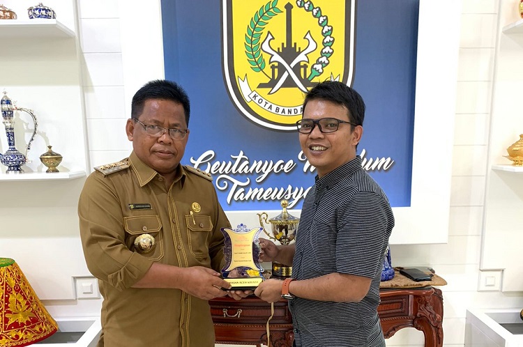 Ketua Yayasan Aceh Kreatif Delky menyerahkan Piagam Penghargaan Penobatan kepada H. Aminullah Usman, SE.Ak, MM di Pendopo Walikota Banda Aceh, (1/3/2022)