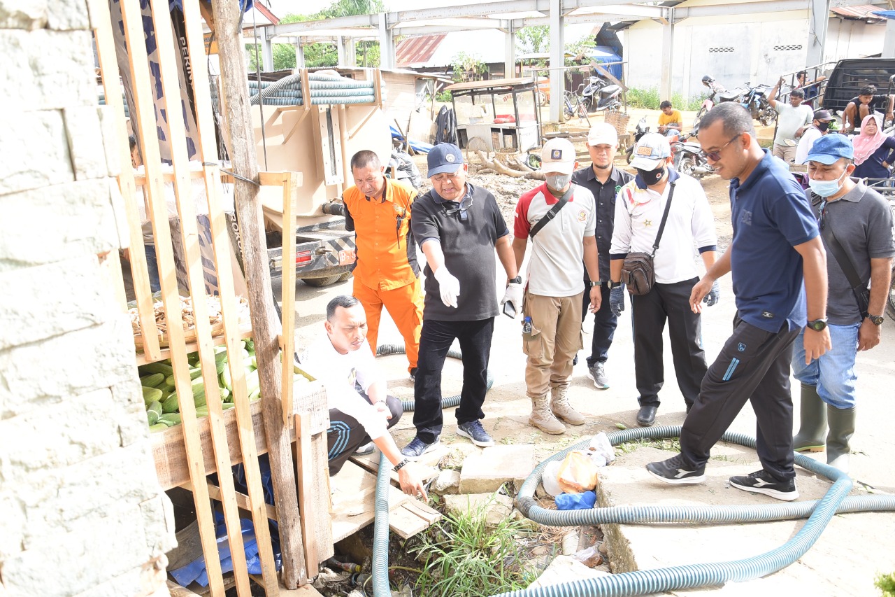 Sekda Asra bersama Kepala DLH Aceh Tamiang, Surya Luthfi, S. STP saat mengecek dan membersihkan drainase yang tersumbat di Pasar Pagi Kota Kuala Simpang. (Foto: Nukilan)