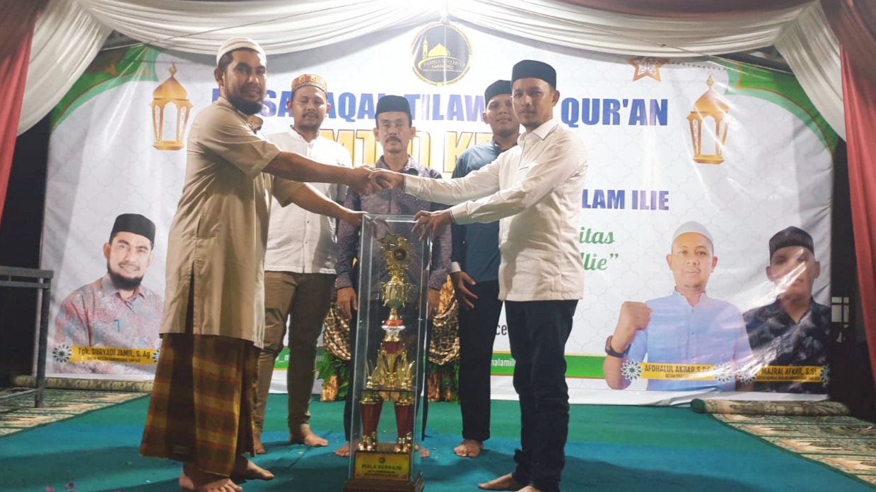 Keuchik Desa Ulee Kareung, Ikhtiar, S.Pd.I saat menerima piala juara umum pada MTQ ke-VII tingkat Kemasjidan Lam Ilie, Kecamatan Indrapuri, Aceh Besar. (Foto: Dok. Ist)