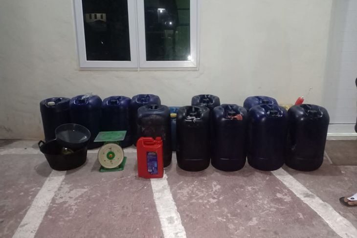 Personel Polres Aceh Selatan menangkap seorang pria yang diduga melakukan penimbunan Bahan Bakar Minyak (BBM) jenis solar, Kamis (14/4/2022). Foto: Antara.