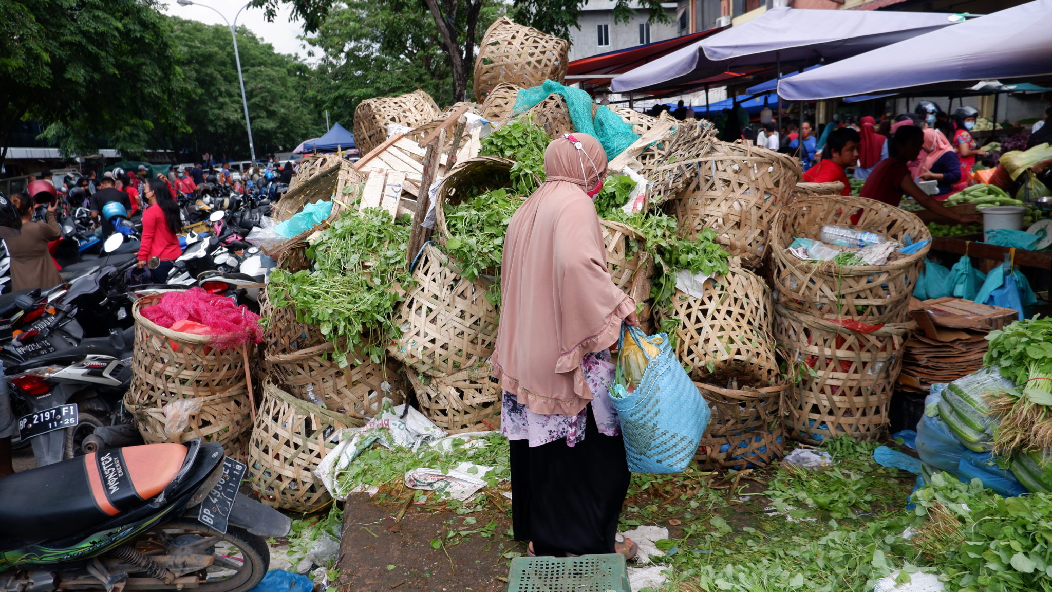 Seorang warga melintasi tumpukan sampah sayur sayuran di Pasar Nagoya Jodoh Kota Batam. (Foto: Mongabay)