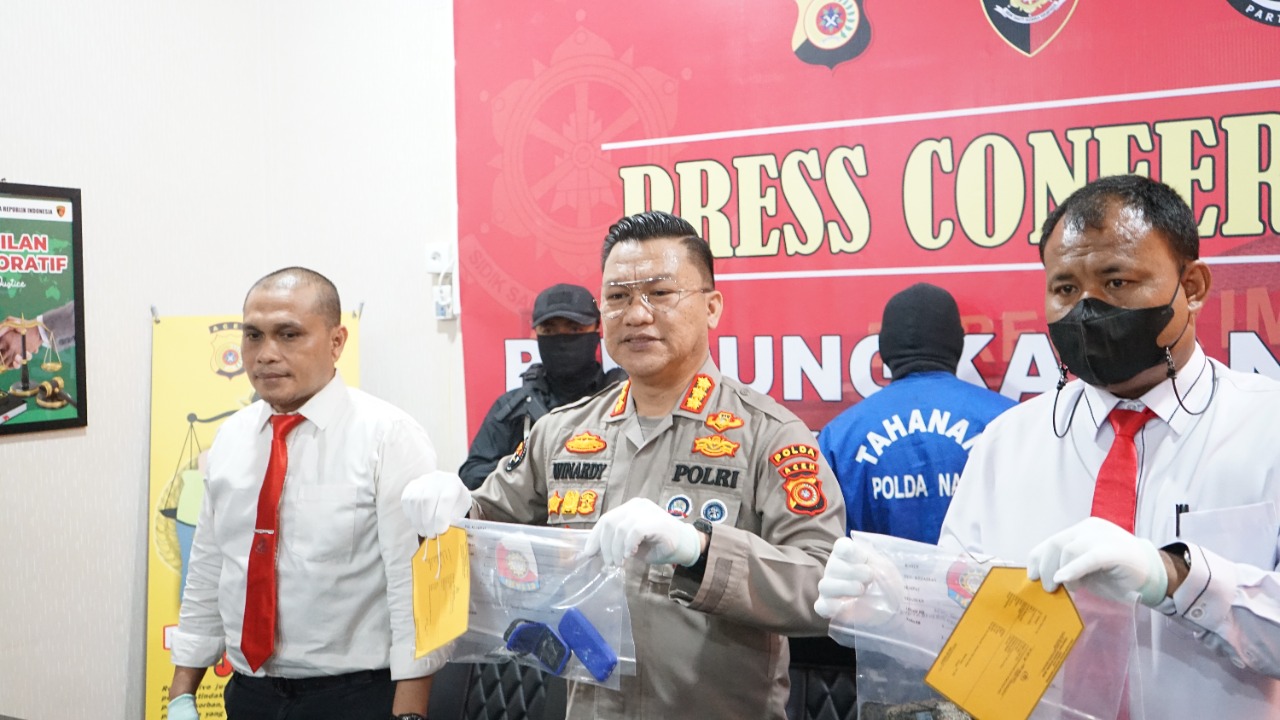 Kombes Pol Winardi saat memperlihatkan barang bukti berupa dua unit handphone. (Foto: Nukilan/Reji)