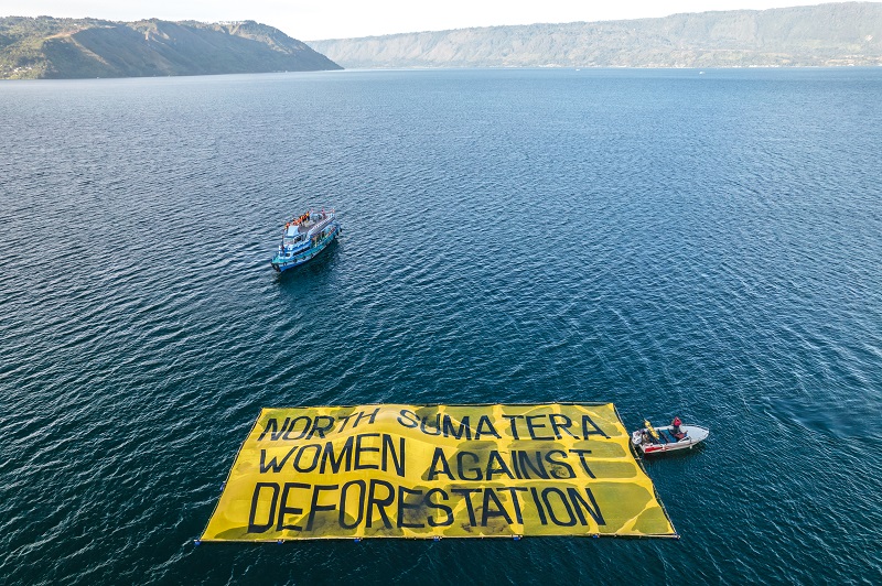 Greenpeace Indonesia joins with the local indigenous organization People's Initiative Development and Study Group (KSPPM) to hold an action with a giant floating banner read "North Sumatera Women Against Deforestation" during the W20 conference in Lake Toba, Parapat, North Sumatra. The action to support Women indigenous people protecting their customary forest in this area that was destroyed by PT Toba Pulp Lestari.