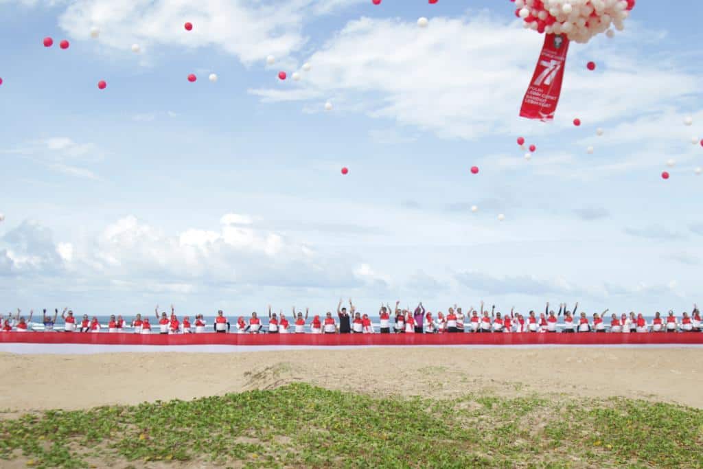 Kodam IM membentangkan bendera merah putih sepanjang 100 meter di Pantai Dream Lhongka, Aceh Besar, Sabtu (20/8/2022). Foto: Nukilan/Wanda