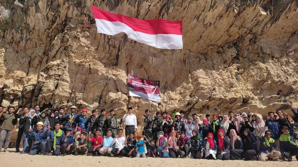 Para Pecinta Alam Gainpala melakukan foto bersama setelah membentangkan bendera raksasa di Tebing Pantai Lampuuk, Lhoknga, Aceh Besar, Rabu (17/8/2022). Foto: Nukilan/Reji.