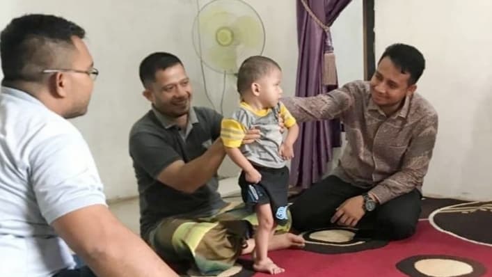 Ketua DPC Demokrat Aceh Besar, Zarwatun Niam saat menjenguk M. Nafis Almaulidi, anak penderita bocon jantun di Gampong Gue, Kuta Baro, Aceh Besar, Selasa (16/8/2022). Foto: Ist.