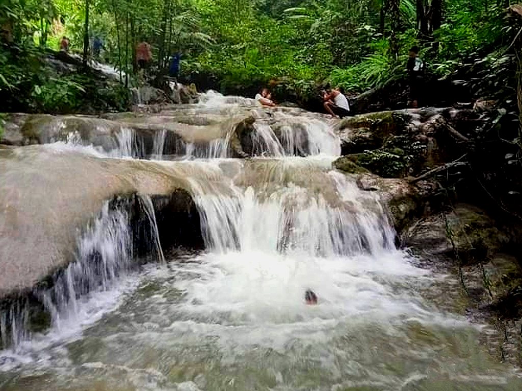 Pengunjung sedang menikmati sensasi arus sungai di bawah aliran Air Terjun seribu di Aceh Tamiang, Aceh, Minggu, 16 Agustus 2020. (Foto: Tagar/Zulfitra)