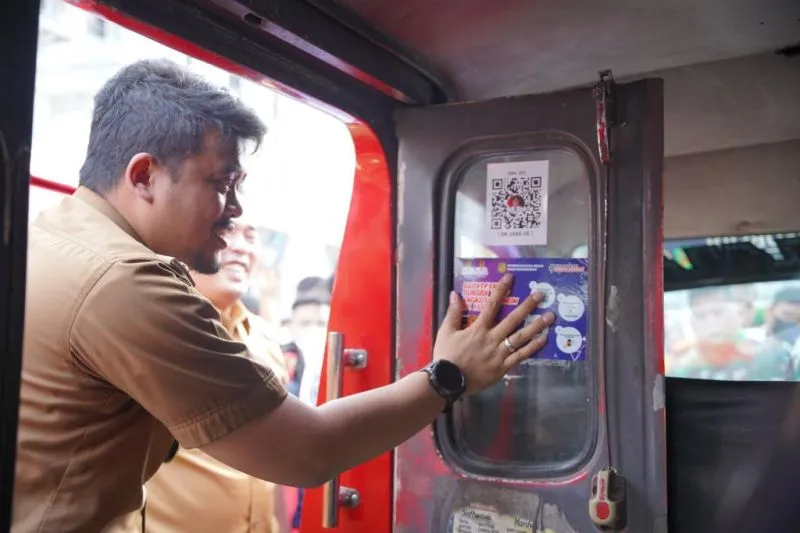 Wali Kota Medan Bobby Nasution menempelkan stiker kode batang (barcode) pada kaca pintu angkot di Kota Medan, Sumatera Utara, Senin (3/10/2022). (ANTARA/HO-Diskominfo Kota Medan)Wali Kota Medan Bobby Nasution menempelkan stiker kode batang (barcode) pada kaca pintu angkot di Kota Medan, Sumatera Utara, Senin (3/10/2022). (ANTARA/HO-Diskominfo Kota Medan)