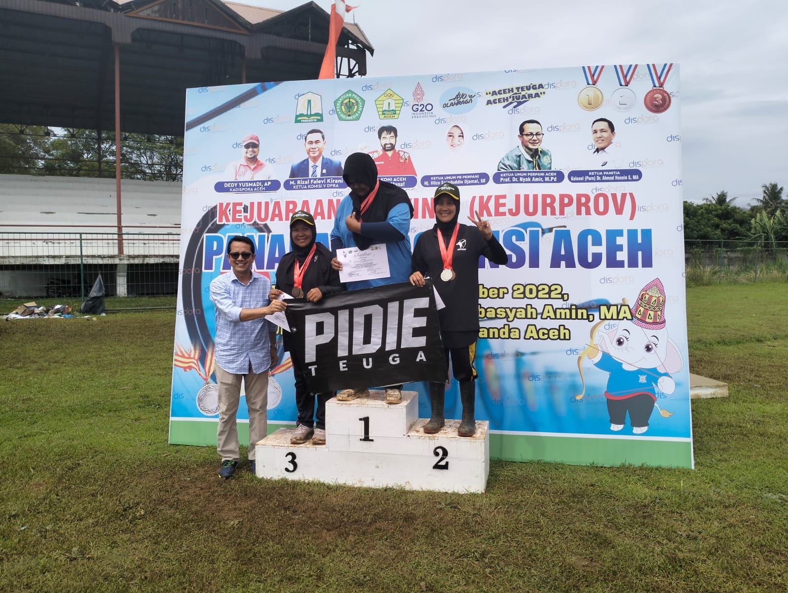 Ketua Umum Pengprov Perpani Aceh, Prof Dr Nyak Amir, M.Pd berpose bersama atlet usai pengalungan medali pada perlombaan terakhir Kejurprov di lapangan Prof Dr Ali Basyah Amin, MA, Stadion Mini, Universitas Syiah Kuala (USK), Darussalam, Banda Aceh, Minggu (13/11/2022) petang. Foto : Humas Perpani Aceh.