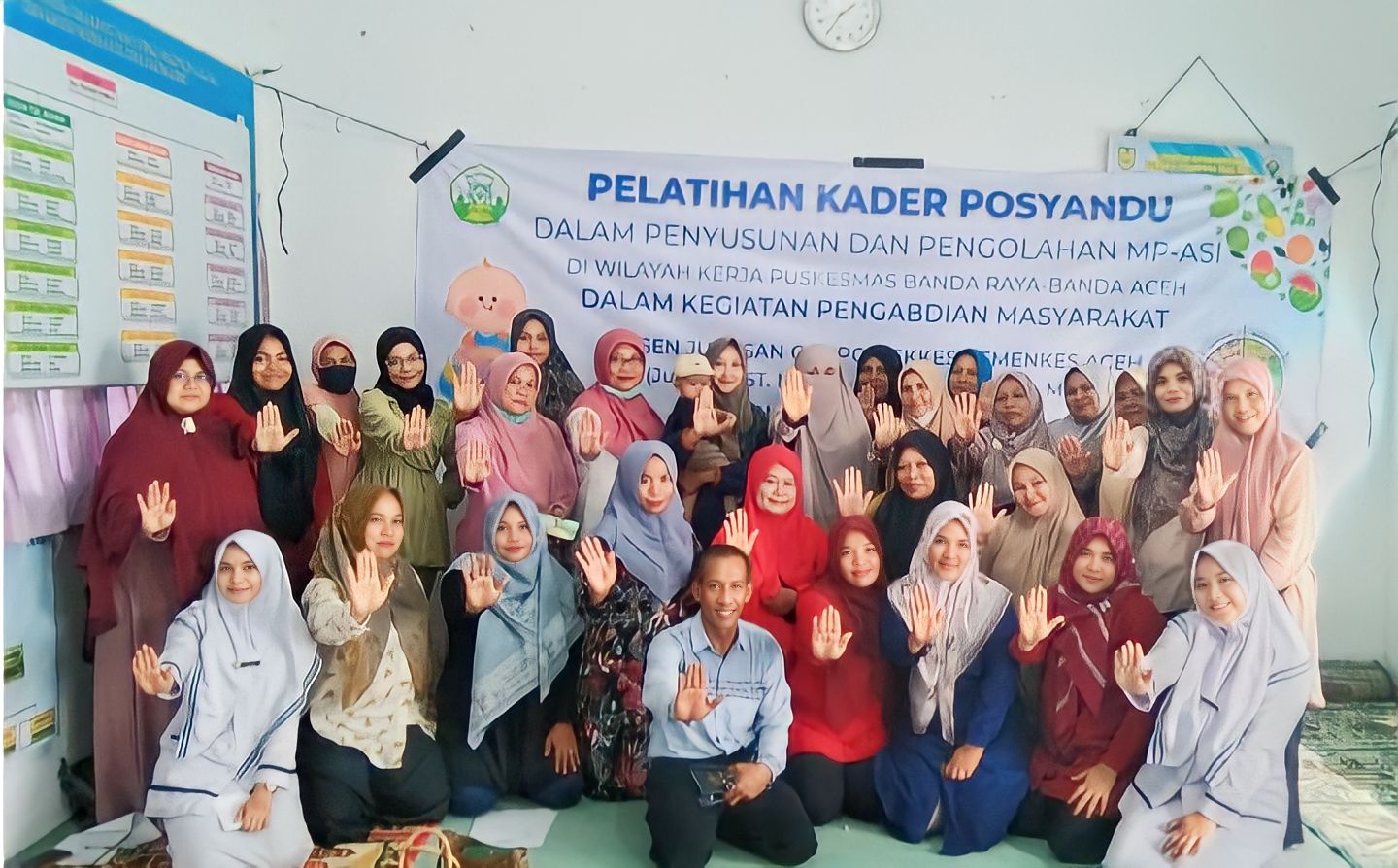 Dosen Poltekkes Kemenkes Aceh, Junaidi, SST, M.Kes melakukan sesi foto bersama pada kegiatan Pelatihan Pegolahan MP-ASI Berbasis Menu Keluarga dan Pangan Lokal kepada para kader Posyandu di Kecamatan Banda Raya, Kota Banda Aceh, Selasa (20/12/2022).