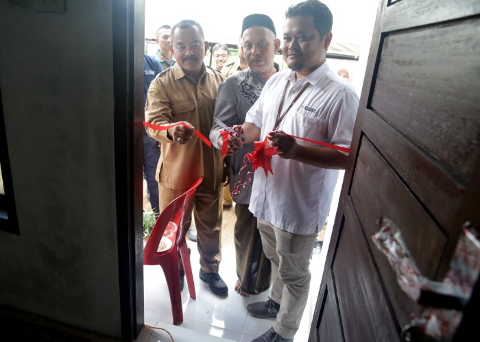 Pj Bupati Aceh Besar, Muhammad Iswanto S.STP, MM diwakili Asisten II bidang Perekonomian dan Pembangunan Sekdakab Aceh Besar, M Ali SSos MSi melakukan potong pita saat penyerahan bantuan rumah dhuafa merupakan program CSR Pt SBA Tahun 2023 di Gampong. (Foto: Ist)