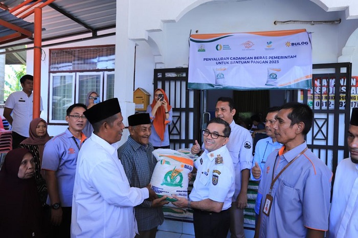 Nukilan.id - Penjabat (Pj) Wali Kota Banda Aceh Bakri Siddiq menyerahkan secara simbolis bantuan pangan berupa beras kepada warga Gampong Sukadamai, Kecamatan Lueng Bata, Rabu, 5 April, 2023. Pangan tersebut merupakan bantuan dari Bulog Aceh untuk 73 Keluarga Penerima Manfaat (KPM) di desa tersebut. (Foto: Ist)