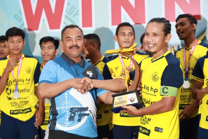 Asisten II Bidang Perekonomian dan Pembangunan Sekdakab Aceh Besar M. Ali S.Sos. MSi menyerahkan hadiah dan piala kepada kapten tim Peska 85 Aneuk Galong Yang Berhasil Menjadi Runner Up Sepak Bola Danlanud Cup 2023, di Lapangan Danlanud SIM. (Foto: Ist)