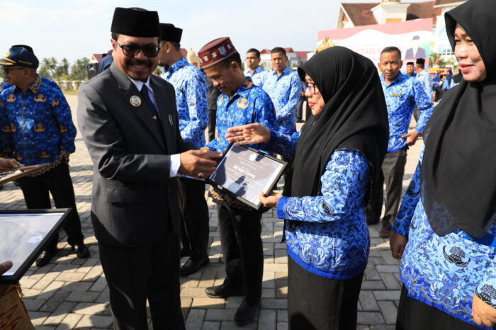 Pj Bupati Aceh Utara Azwardi menyerahkan penghargaan Hardiknas secara simbolis setelah kegiatan upacara Hardiknas di Lapangan Landing, Kecamatan Lhoksukon, Aceh Utara, Selasa (2/5/2023).