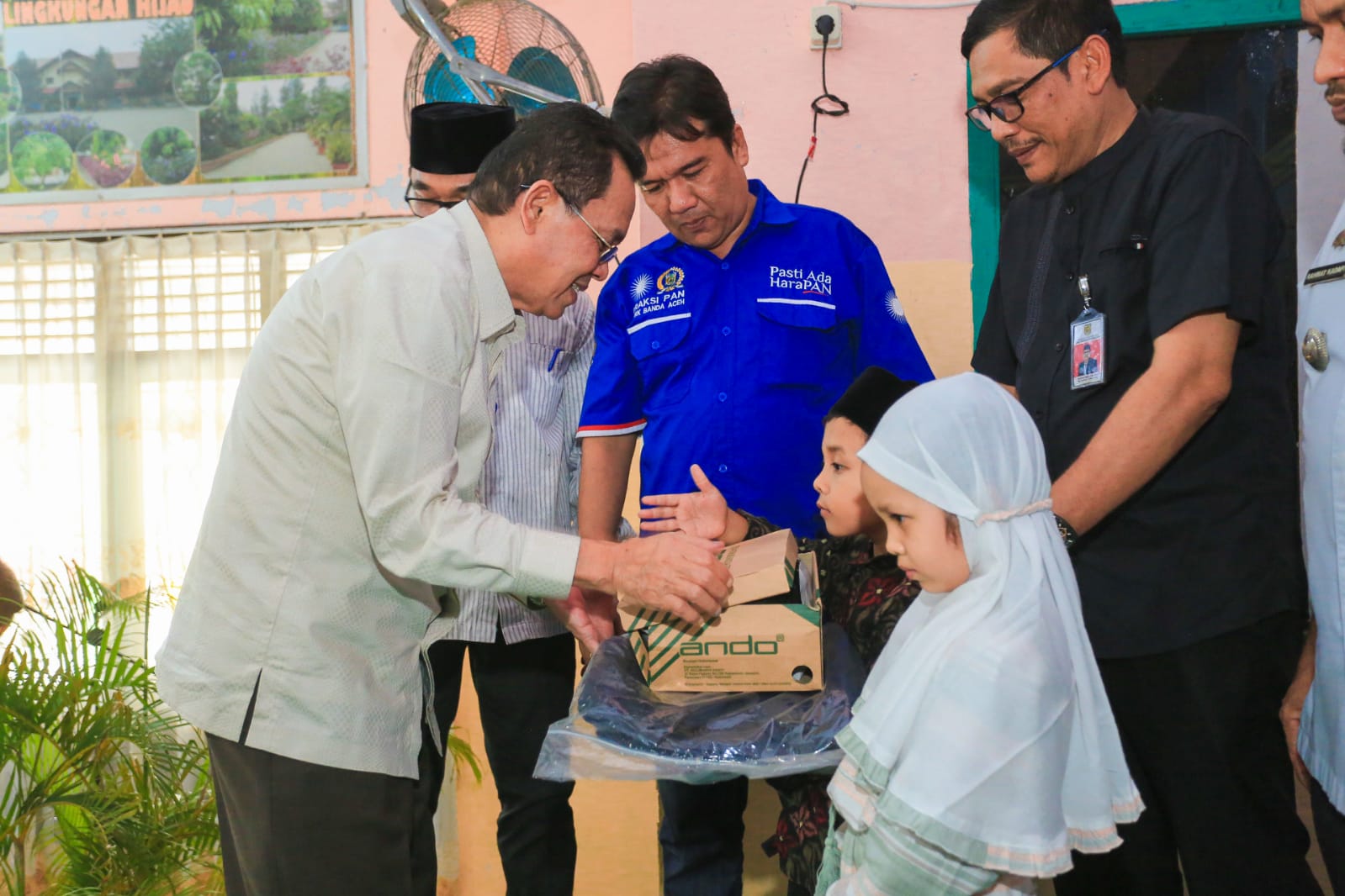 Pj Wali Kota Banda Aceh Amiruddin (kiri) saat  menyerahkan anak yatim. (Foto: Humas Pemko)