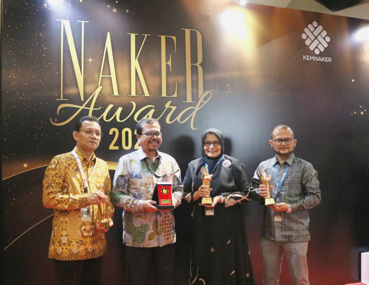 Asisten I Sekda Aceh Azwardi Abdullah AP MSi (tengah) didampingi Kepala Dinas Tenaga Kerja dan Mobilitas Penduduk Aceh Akmil Husen, SE, M.Si serta dari dua perusahaan asal Aceh, saat menerima penghargaan Naker Award 2023.