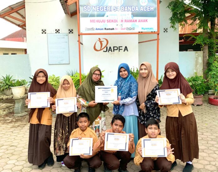 Direktur Anggola Education, Fika Anggola menyerahkan piagan penghargaan kepada perwakilan SDN 54 Banda Aceh. (Foto: Dok. Pribadi)