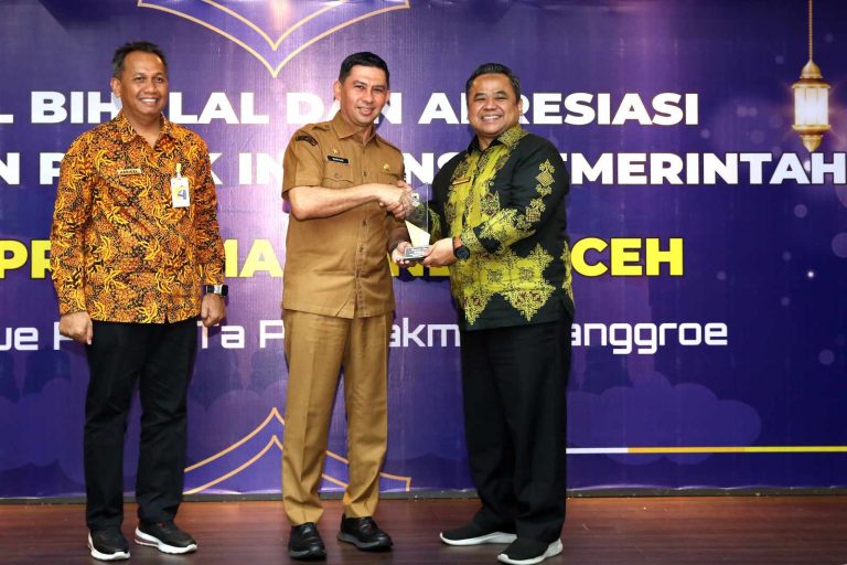 Kepala Kantor Pajak Banda Aceh, Muhammad Taufiqullah Al Mahdy menyerahkan penghargaan kepada Pj Sekdakota Wahyudi . (Foto: Humas Kota Banda Aceh)