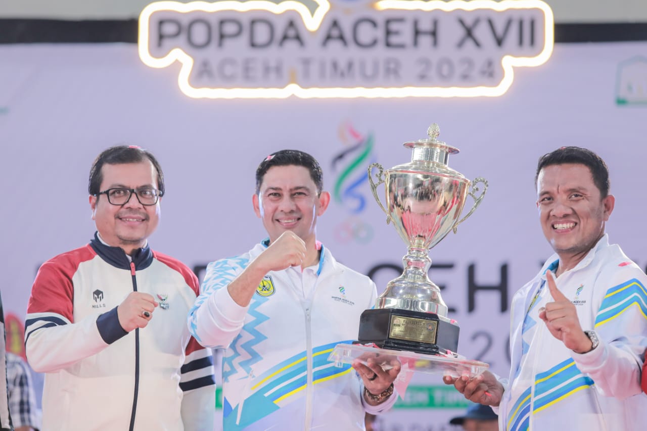 Pj Sekdakota Banda Aceh Wahyudi menerima piala bergilir yang diserahkan Pj Sekdaprov Azwardi pada seremonial penutupan. (Foto: Diskominfo BNA)