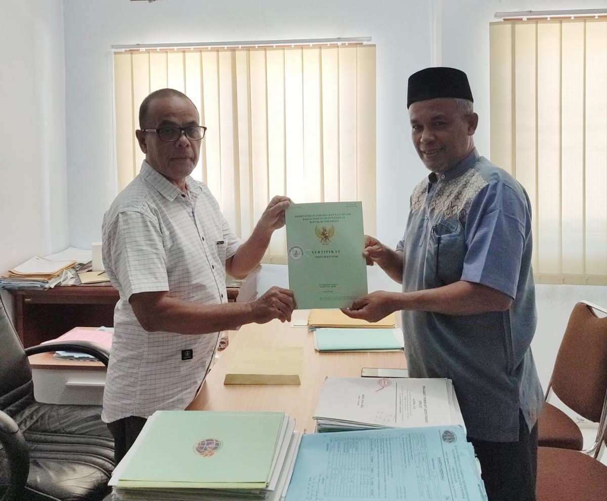 Plh Kakankemenag Aceh Besar Khalid Wardana menerima sertifikat tanah KUA Pulo Aceh dari BPN. (Foto: Kemenag Aceh)