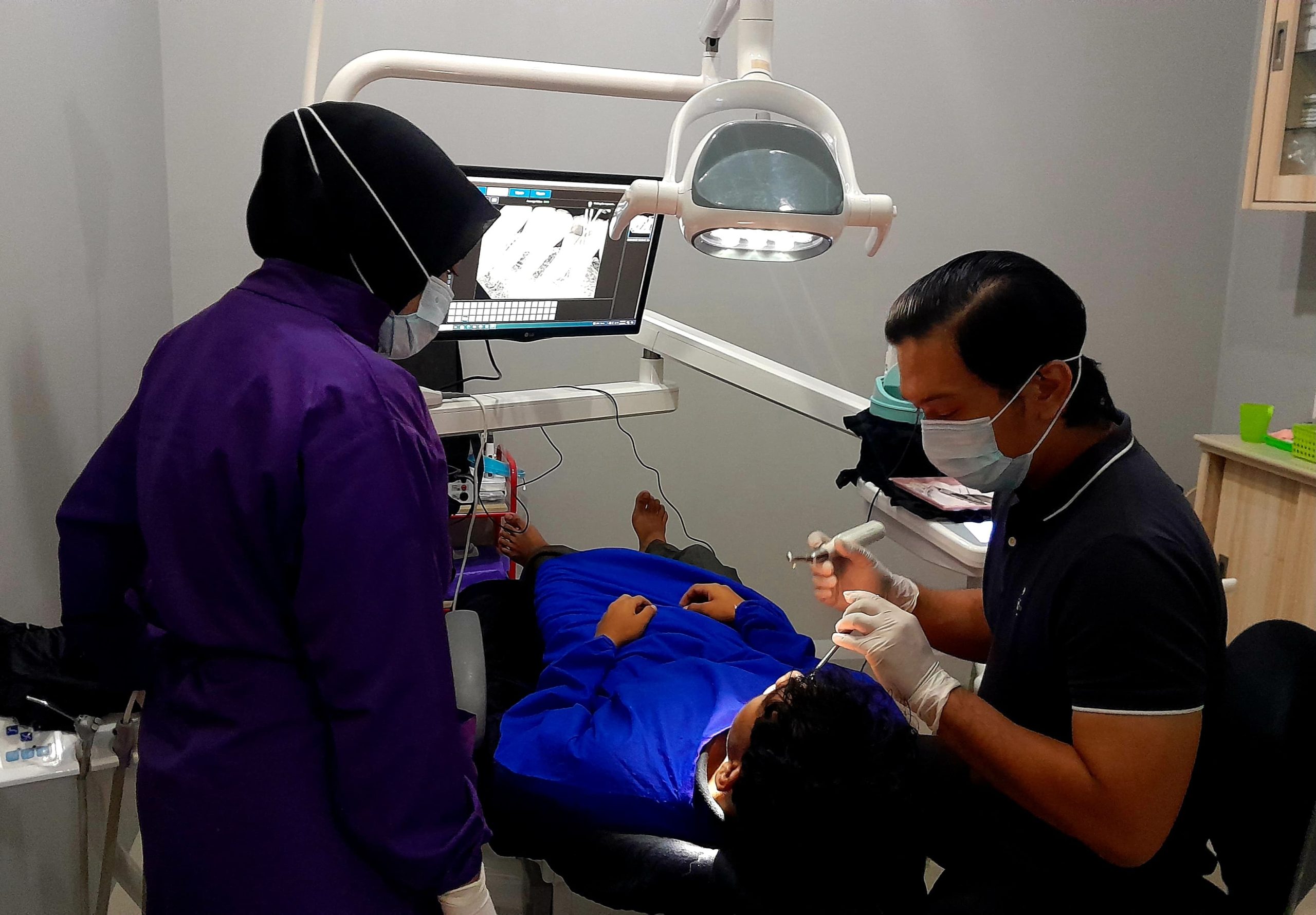 Dokter dan perawat gigi sedang melakukan pemeriksaan gigi pasien di NCB Dental Care Banda Aceh. (Foto: Nukilan)