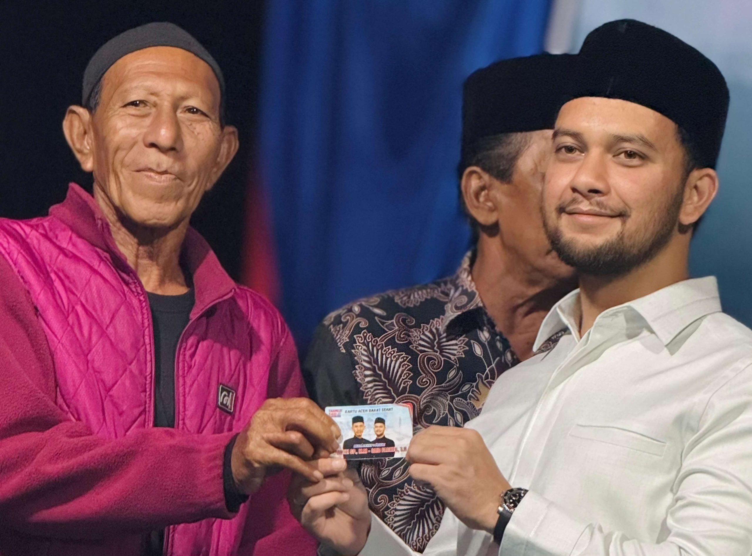 Calon Wakil Bupati Aceh Barat Said Fadheil (kanan) menyerahkan kartu sehat paslon nomor urut 1, kepada warga Desa Rundeng, Aceh Barat. (Foto: For Nukilan)