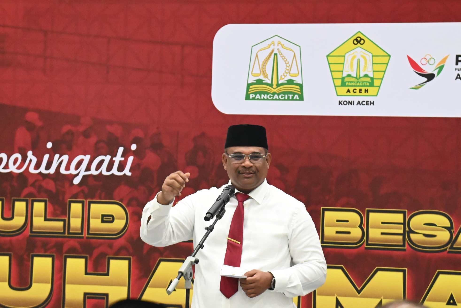 Pj Gubernur Aceh Dr. H. Safrizal ZA, M.Si, saat memberikan sambutan di acara Peringatan Maulid Nabi Muhammad SAW 1446 H di GOR KONI Aceh. (Foto: MC Aceh)