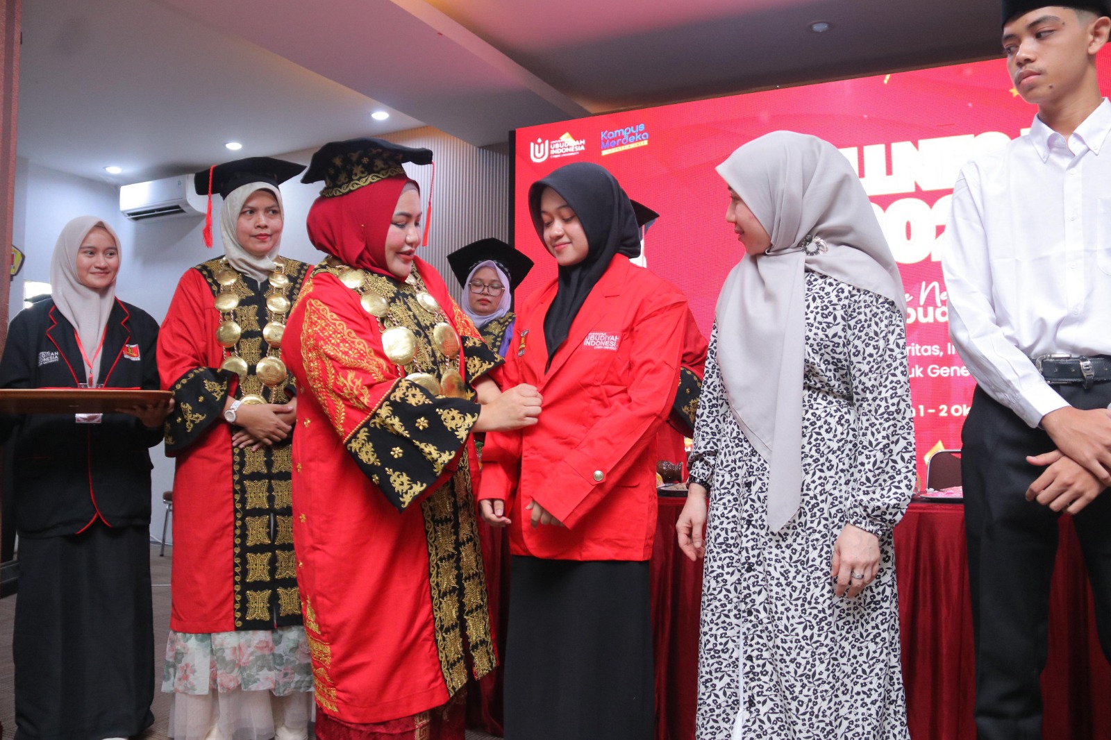 Rektor UUI Prof Adjunct Dr Marniati MKes memakaikan almamater kepada mahasiswa baru UUI 2024/2025 sebagai simbolis penyerahan mahasiswa yang berlangsung di Plenary Hall UUI, Banda Aceh. (Foto: For Nukilan)