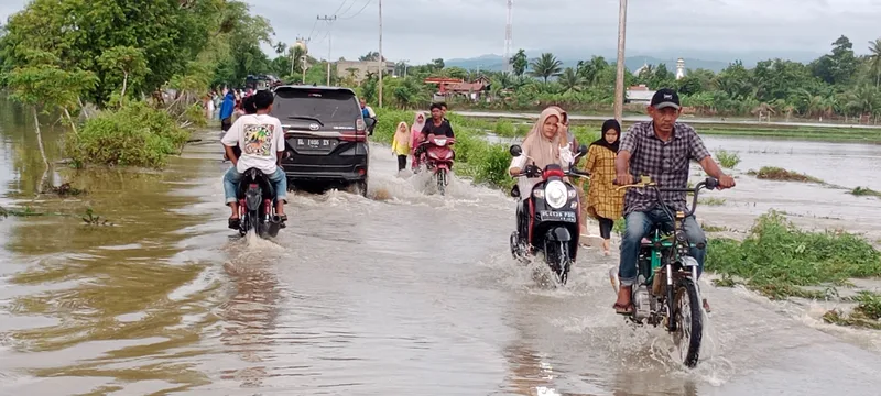 Warga melewati jalanan yang terendam banjir di Kabupaten Pidie, Aceh. (Foto: MI/Amiruddin Abdullah Reubie)