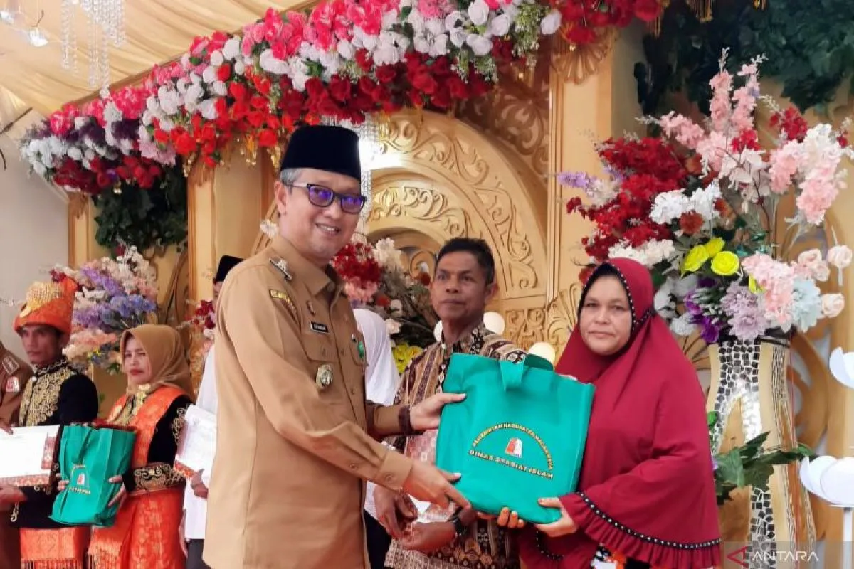 Pj Bupati Nagan Raya, Aceh, Iskandar memberi bingkisan kepada pasangan yang mengikuti isbat nikah di halaman Kantor Camat Beutong Ateuh Banggalang. (Foto: ANTARA)