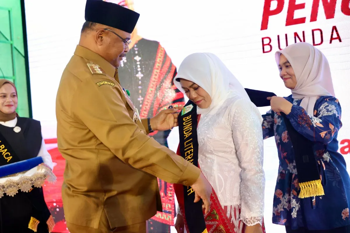 Pj Gubernur Aceh Safrizal ZA mengukuhkan Hj Safriati sebagai Bunda Literasi Aceh, di Perpustakaan Wilayah Aceh. (Foto: HUMAS  ACEH)