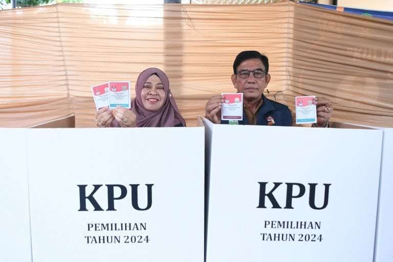 Plt Sekda Aceh, Muhammad Diwarsyah dan istri menyalurkan hak suaranya di TPS.(Foto: Humas Aceh Prov)