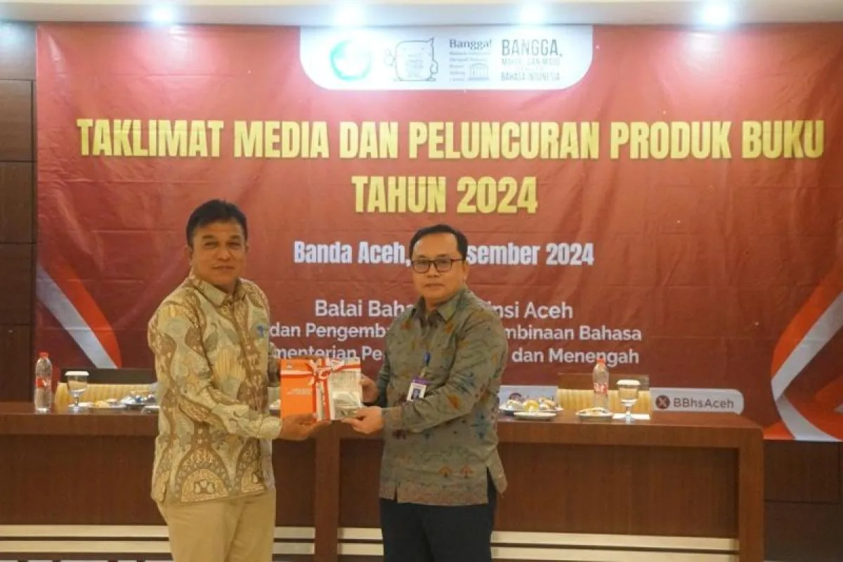 Kepala Balai Bahasa Aceh, Umar Solikhan (kanan) menyerahkan secara símbolis Kamus Bahasa Gayo dan 60 buku cerita anak Bahasa daerah Aceh kepada epala Cabang Dinas Pendidikan (Kacabdin) Banda Aceh-Aceh Besar. (Foto: ANTARA)
