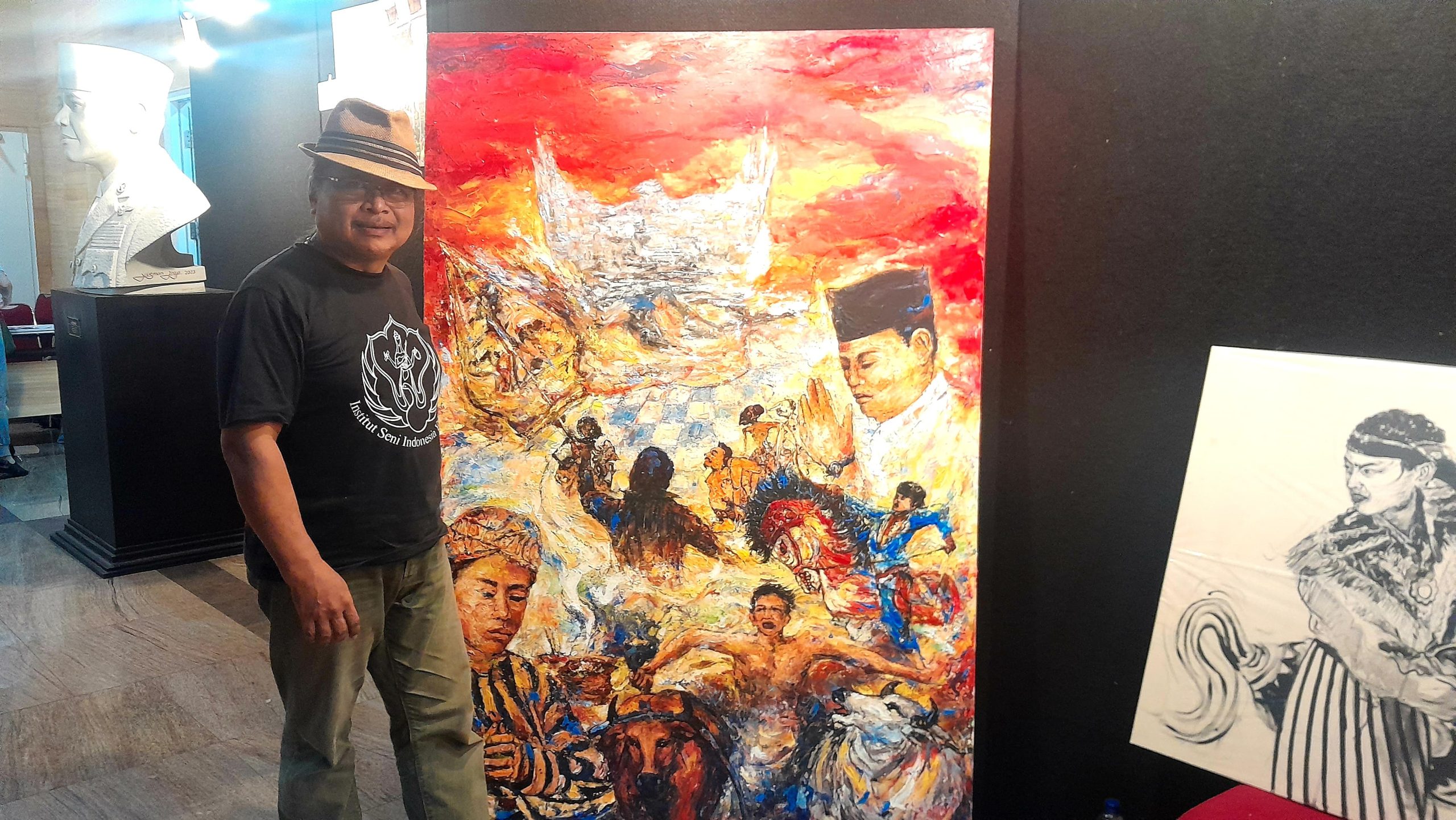 Pelukis dengan lukisannya di Lantai 4 Gedung Perpusnas RI. (Foto: Nukilan)