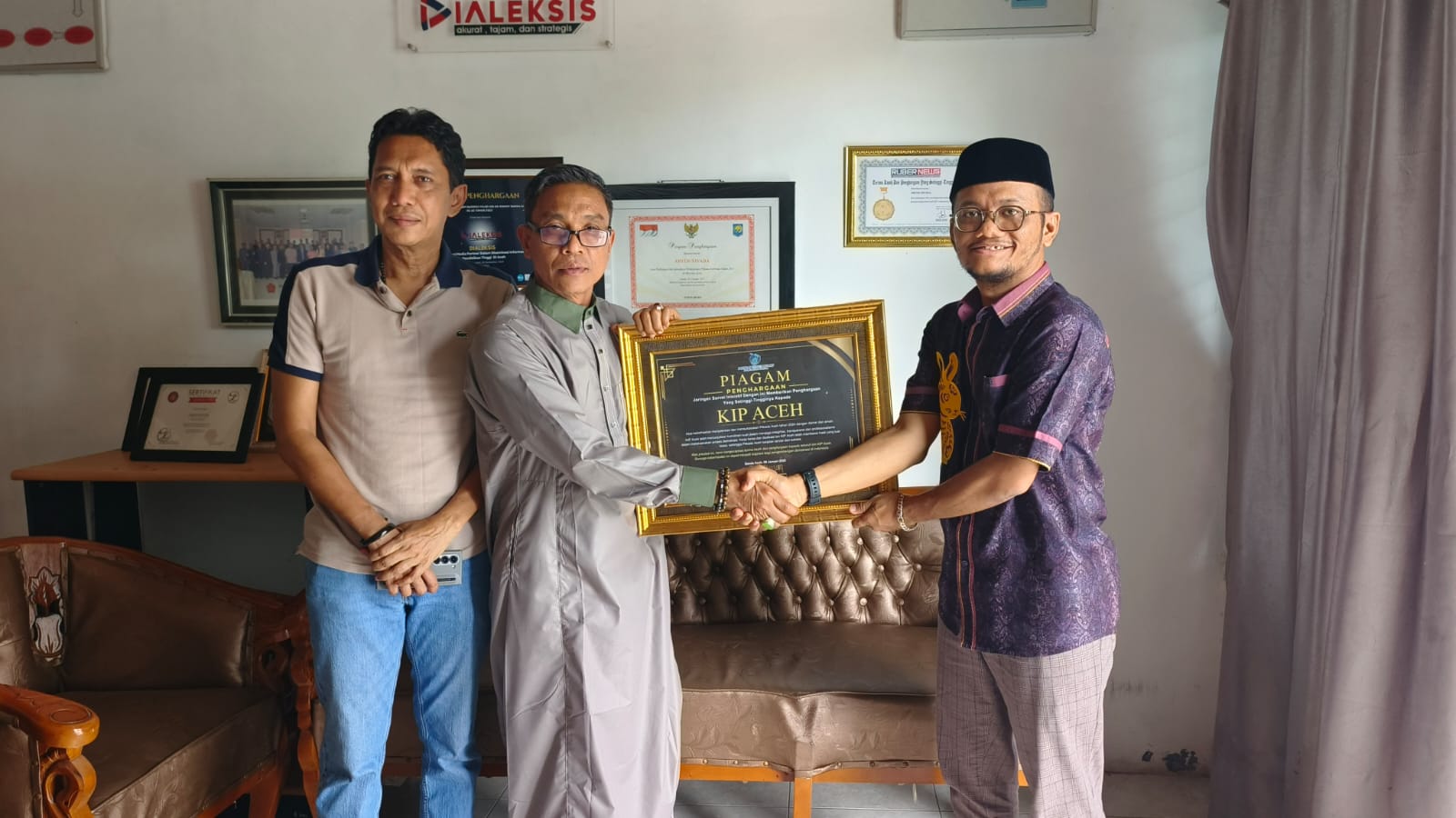 Pendiri JSI, Aryos Nivada, kepada Ketua KIP Aceh, Agusni AH, didampingi Wakil Ketua KIP Aceh, Iskandar Agani. (Foto: Nukilan)