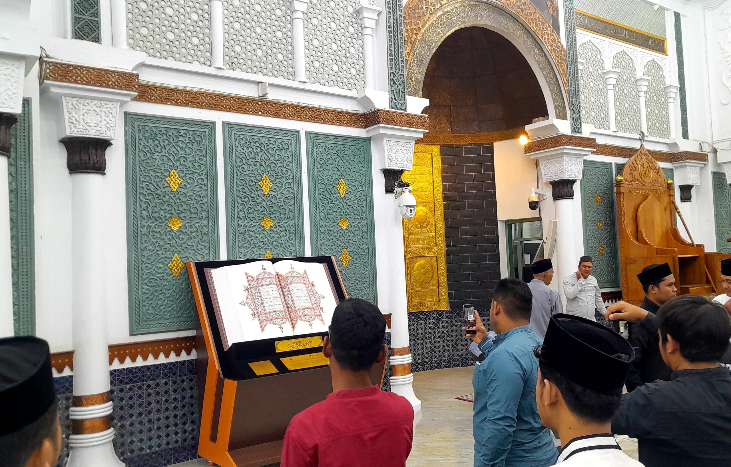 Pengunjung antusias mengabadikan duplikat mushaf Baiturrahman. (Foto: Nukilan)