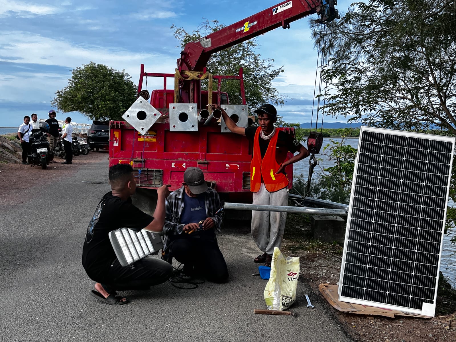 Proses pemasangan lampu lampu tenaga surya (solar panel) di sepanjang jalan menuju Pantai Ulee Lheue, pada Rabu 14 Mei 2025. (Foto: Nukilan/Rezi)